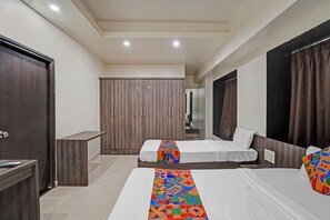 A hotel room with two beds, a wardrobe, and a desk. - Fabhotel Royal Inn I (Pune)