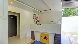 A reception area with a 'fab hotels' sign, a reception desk, a notice board, and a door marked '101'. - Fabhotel Royal Inn I (Pune)