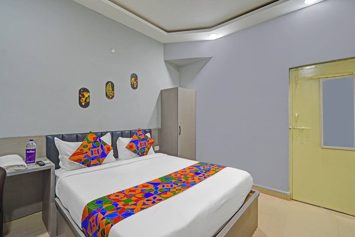 A hotel room with a bed, a nightstand, a wardrobe, and a door.