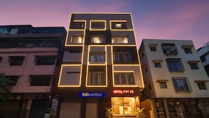 A multi-story hotel building with a modern design, featuring a prominent entrance with steps and potted plants. - Fabhotel Top 22 (Kolkata)