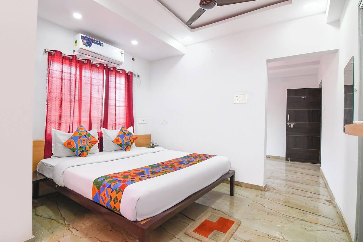 A bedroom with a bed, red curtains, a ceiling fan, and a door marked 401.