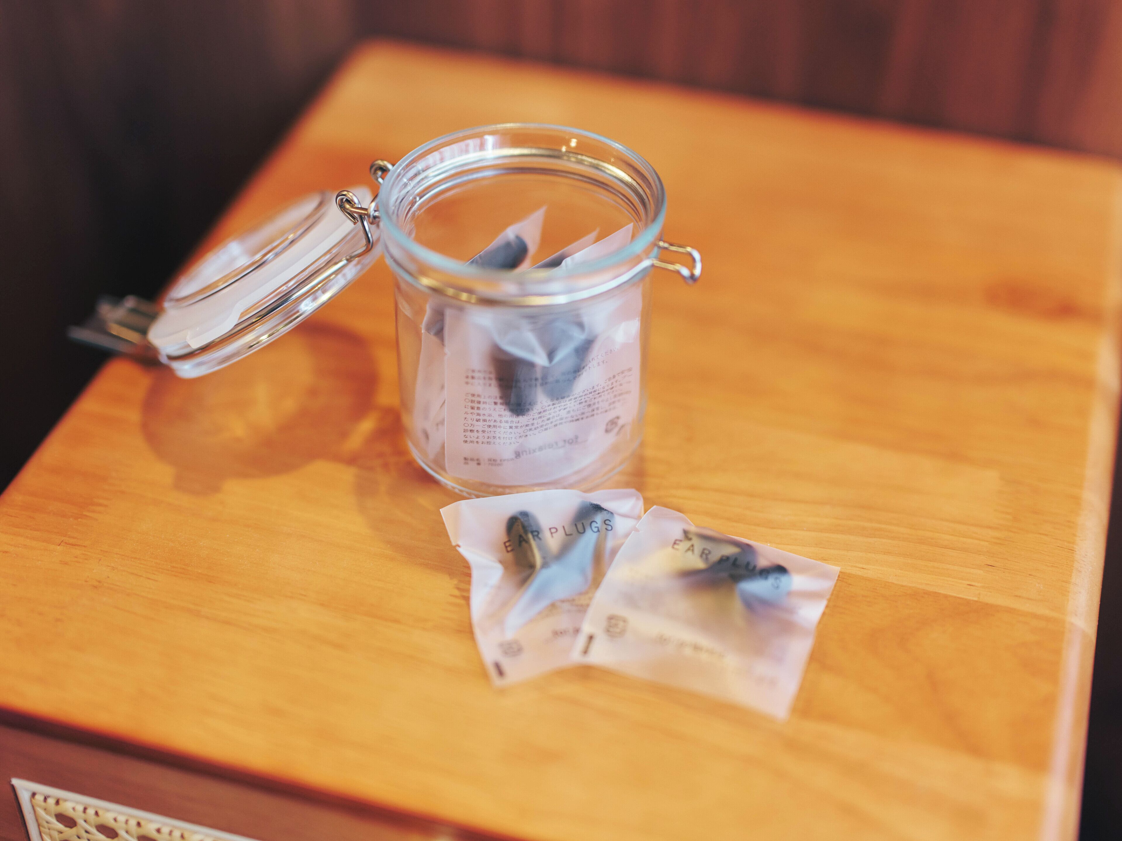 A glass jar with a metal clasp lid on a wooden table.