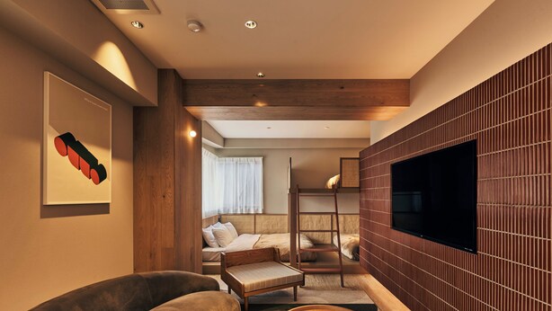 A modern hotel room with a sofa, a small round table, a bunk bed, and a TV mounted on the wall. - illi Mia Kinshicho (Tokyo)