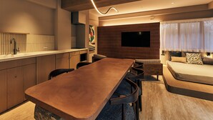 A modern kitchen with a wooden countertop, a built-in stove, and a large flat-screen TV mounted on the wall. - illi Mia Kinshicho (Tokyo)