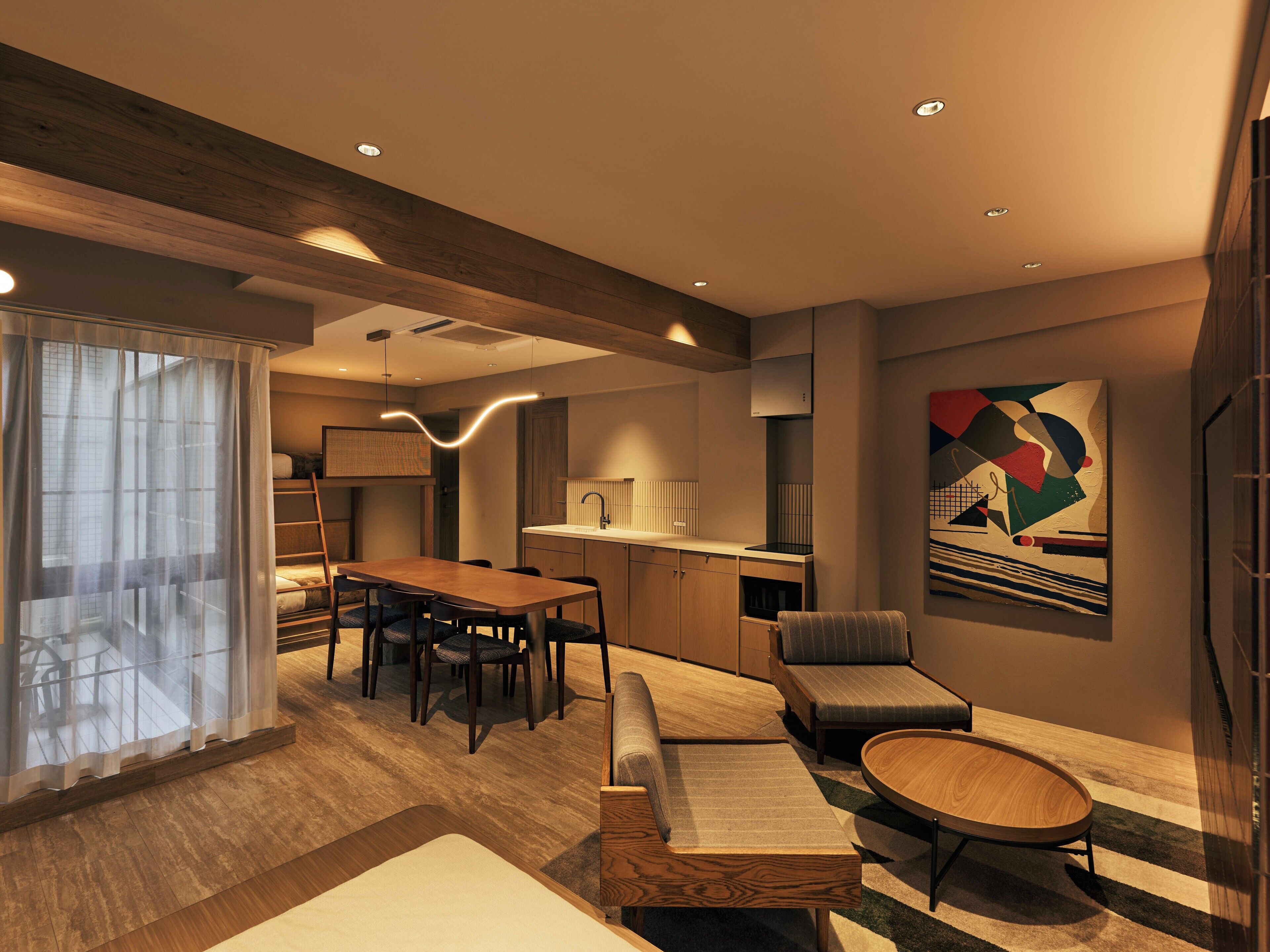 A modern living room with a dining area, a kitchen, and a large window with curtains.