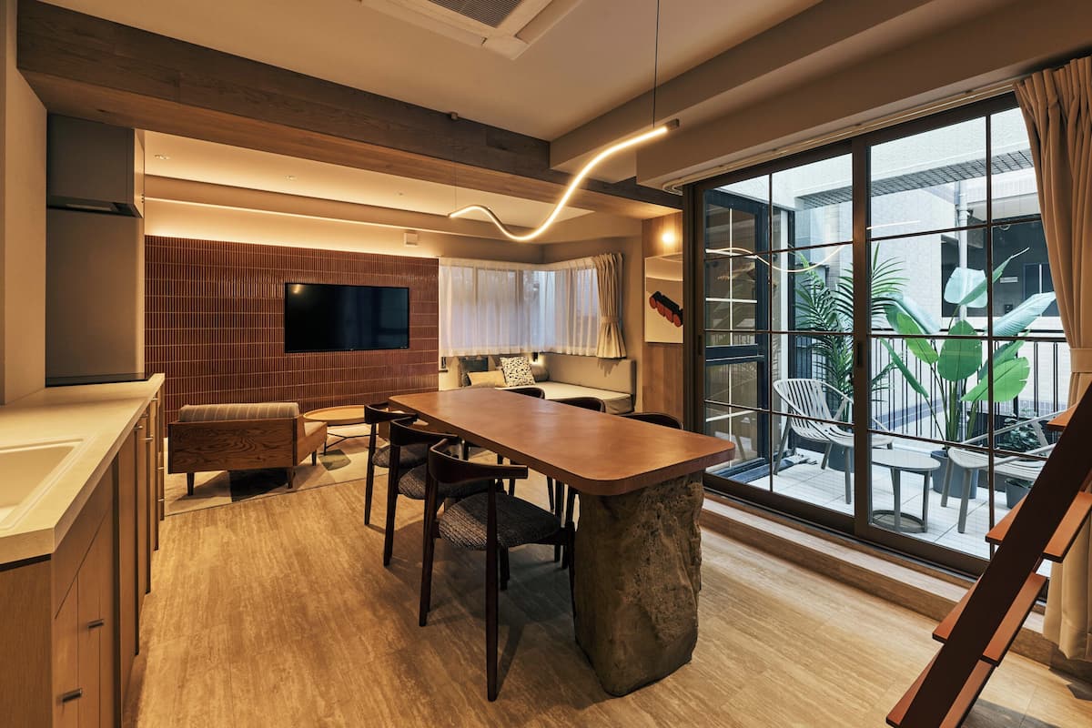 A modern kitchen with a central island, built-in appliances, and a large window with a view of the outdoors.