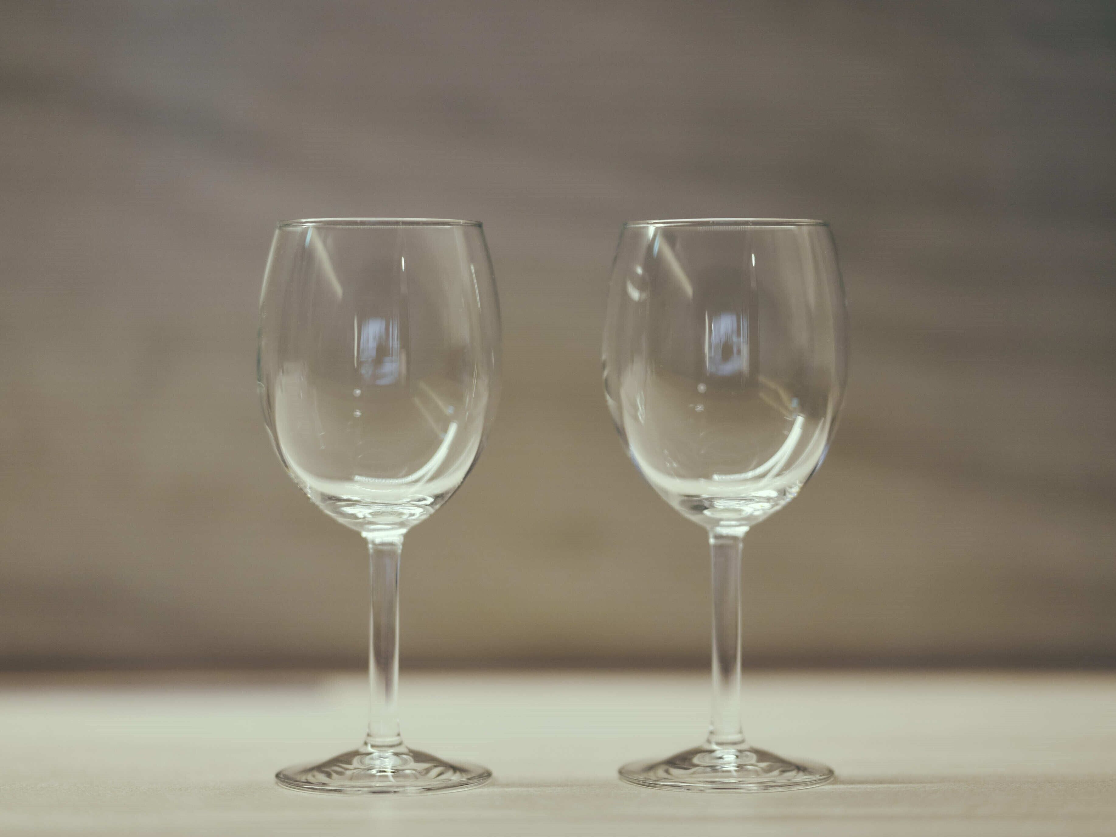 Two empty wine glasses on a table.