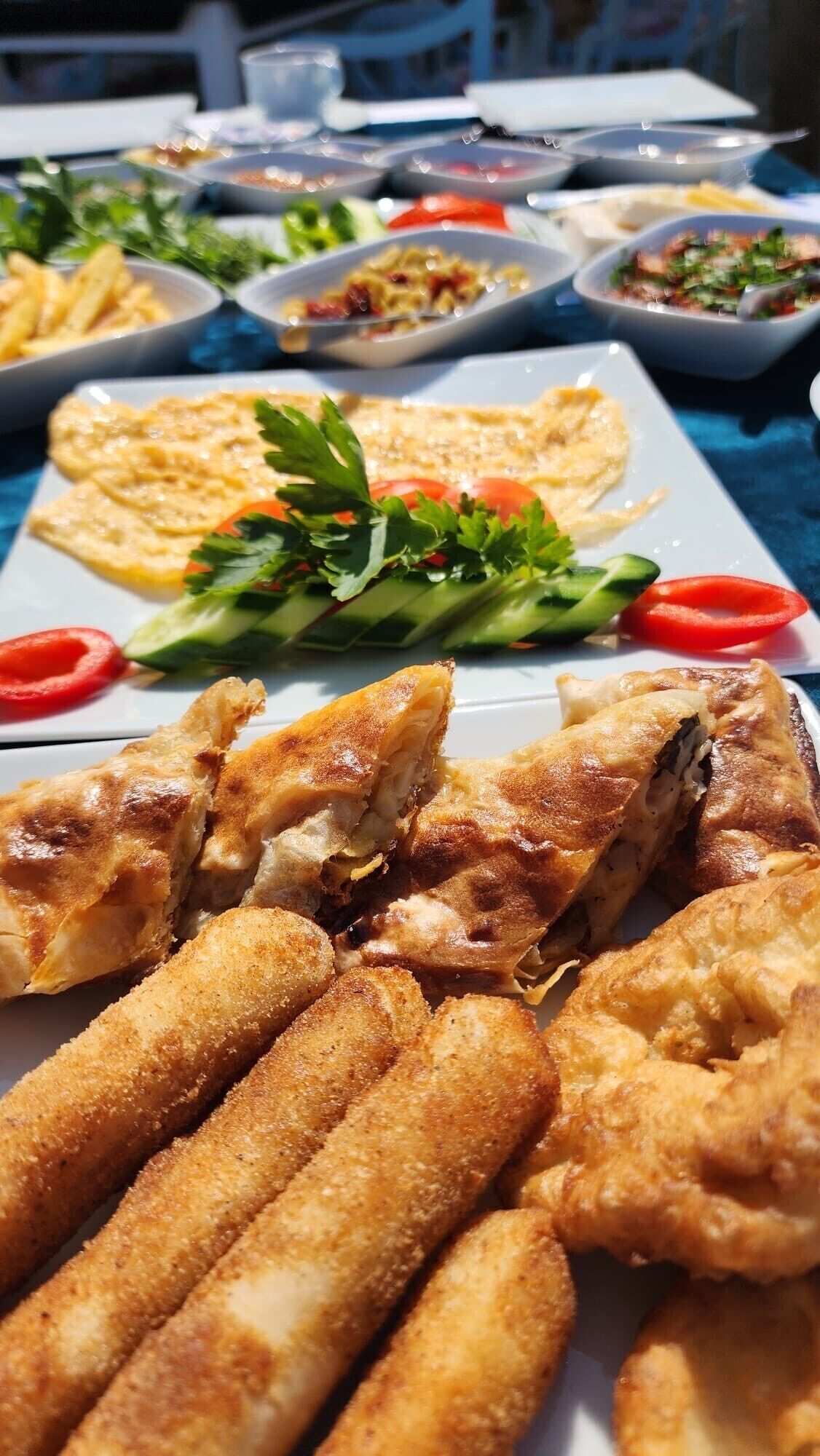 A buffet table with various dishes including fried items and a salad.