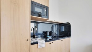 Une cuisine équipée d’un four à micro-ondes, d’un grille-pain et d’un évier.