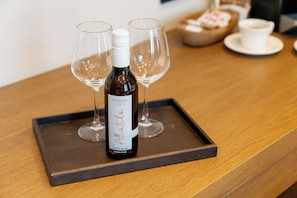 Una botella de vino sobre una bandeja con dos copas de vino vacías.