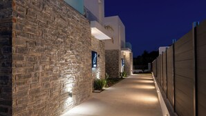 Ein Gebäude mit Steinwänden, beleuchteter Beschilderung, einem Betonweg und einem verschlossenen Bereich.