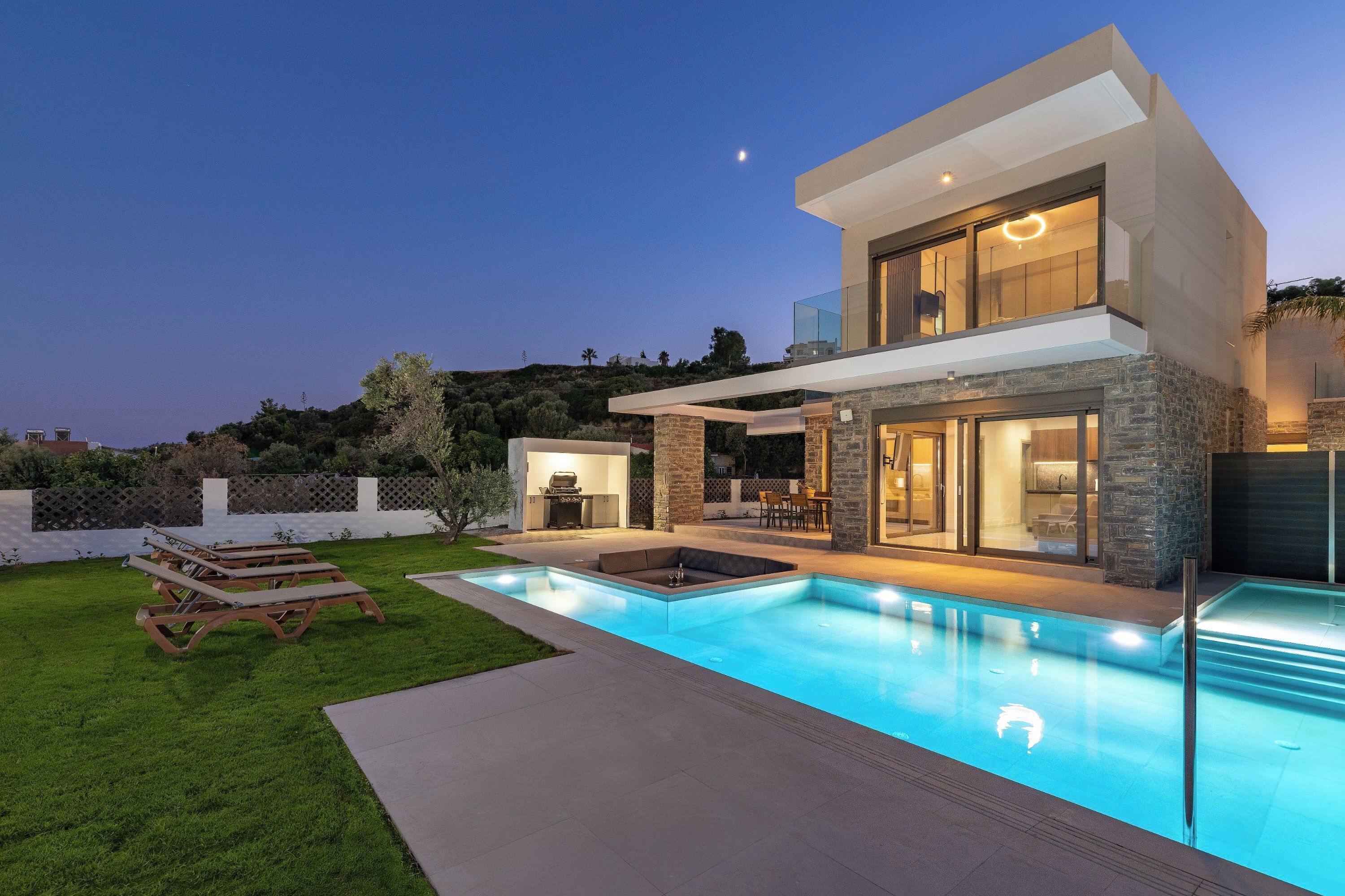 A modern two-story house with a swimming pool, outdoor seating, and a patio area.