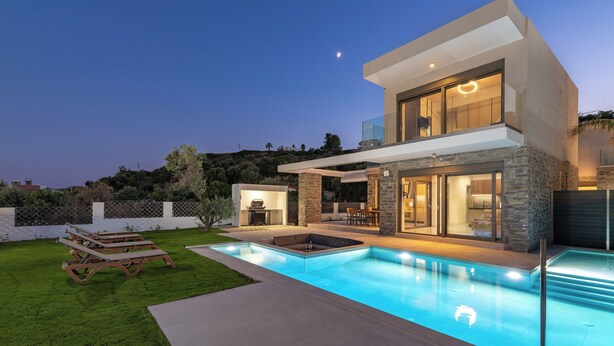 Ein modernes, zweistöckiges Haus mit Swimmingpool, Außenbereich zum Sitzen und einer Terrasse.