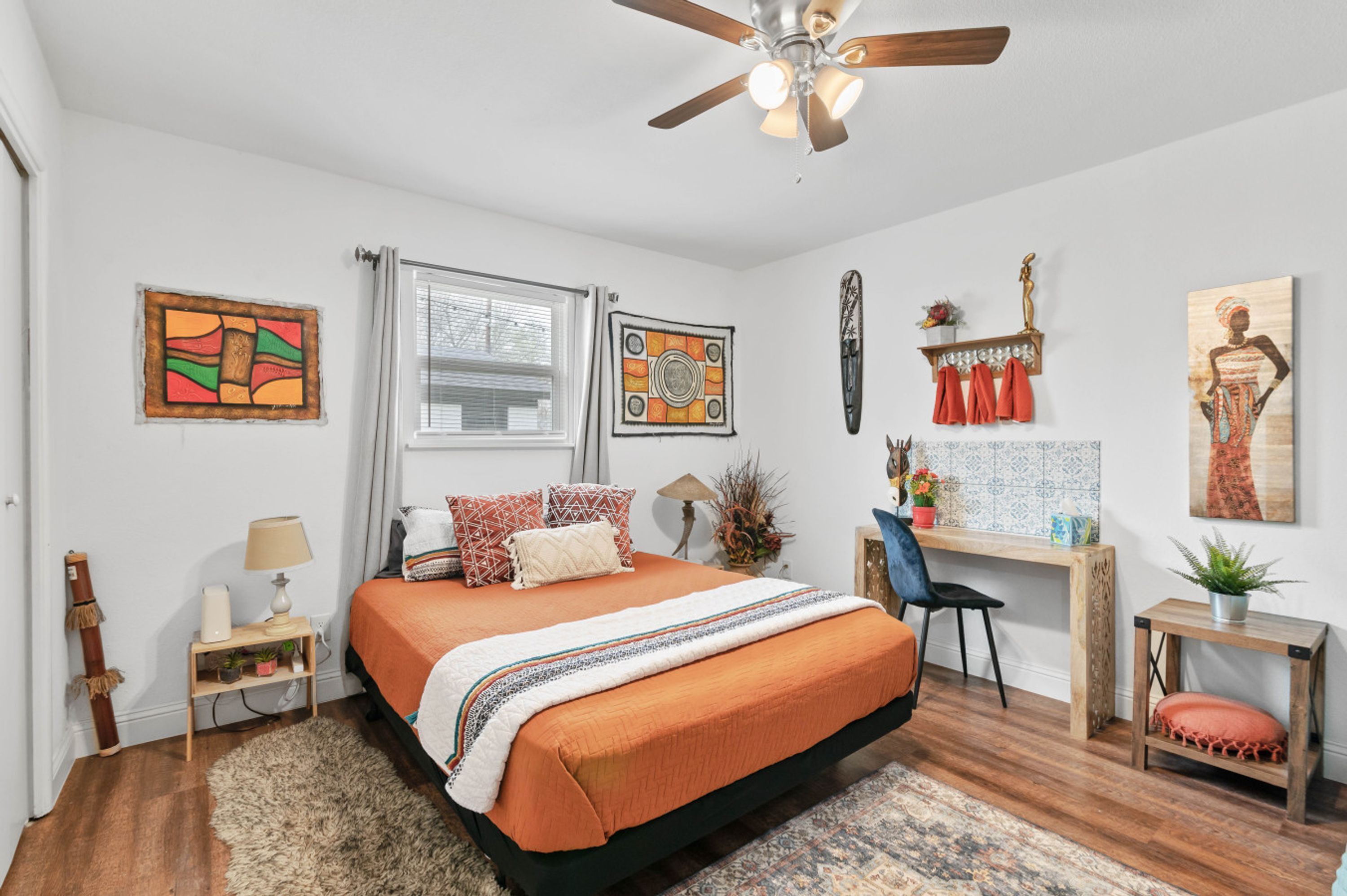 A bedroom with a bed, a desk, and a chair.