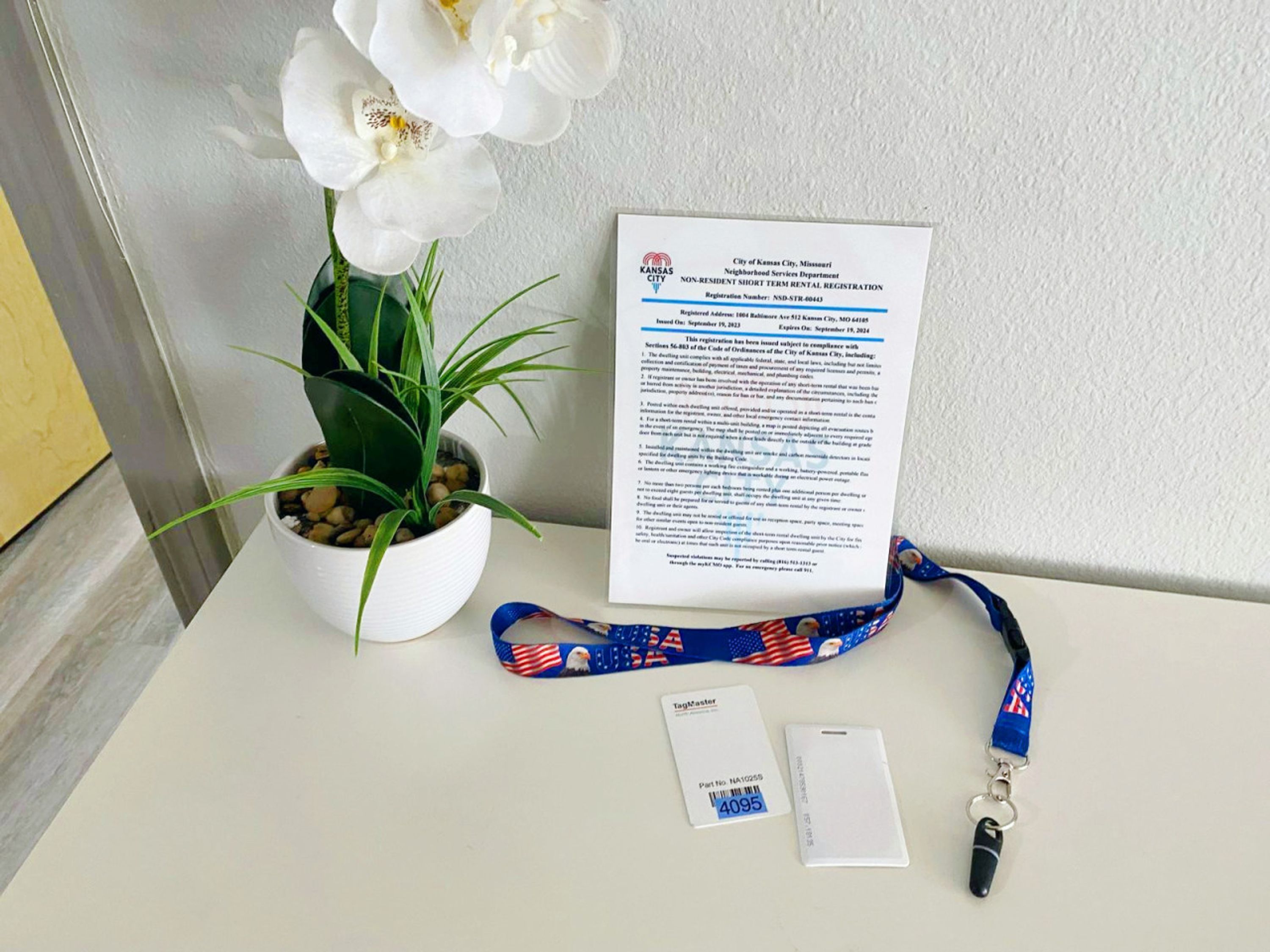 Un documento de registro de alquiler, una tarjeta TagMaster y un cordón con llavero sobre una mesa.