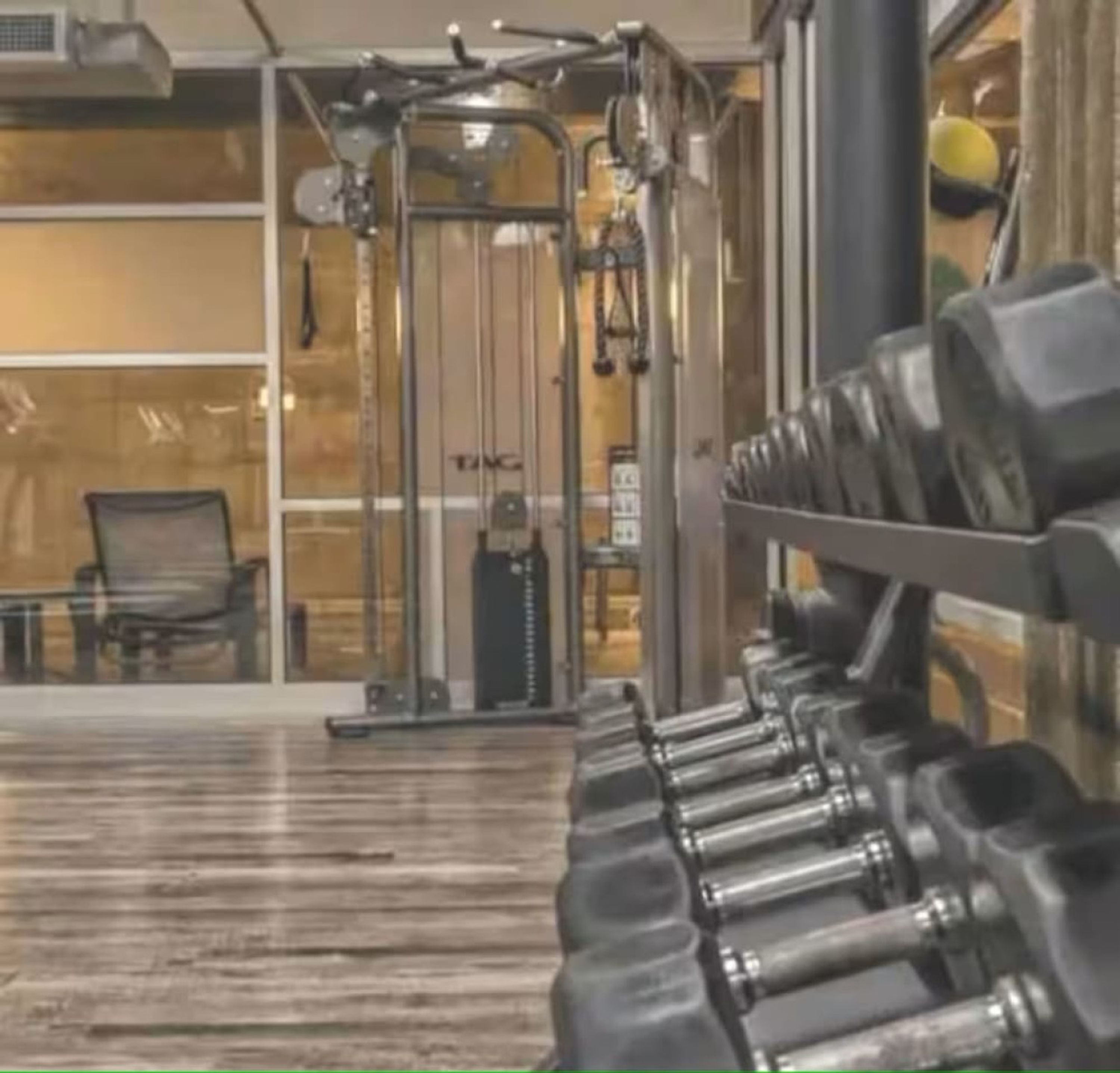 A gym with exercise equipment and dumbbells.