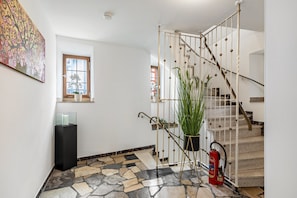 Eine Treppe mit Metallgeländer, einem Blumentopf und einem Feuerlöscher.