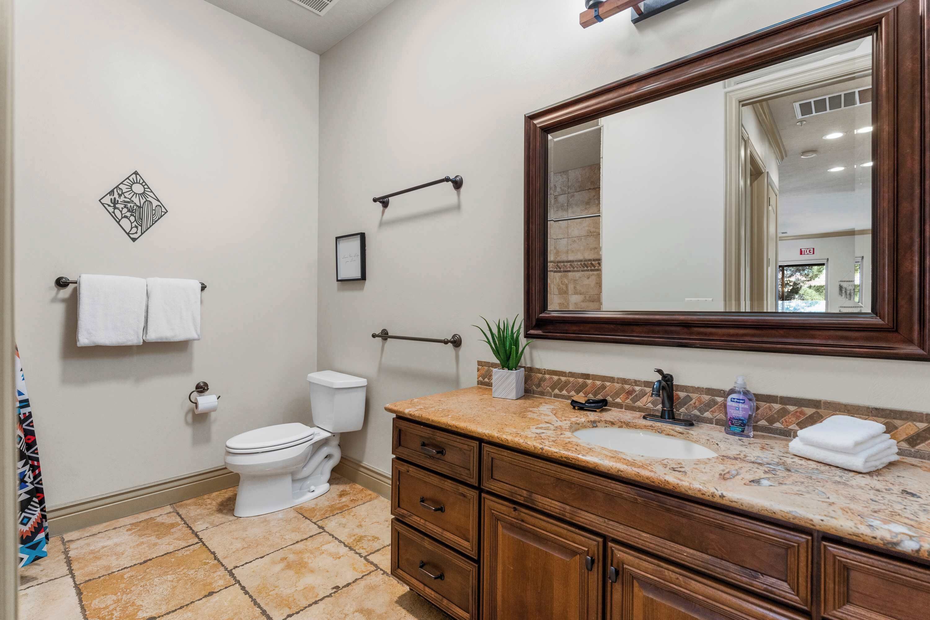 Un baño con inodoro, lavamanos y tocador con cajones.