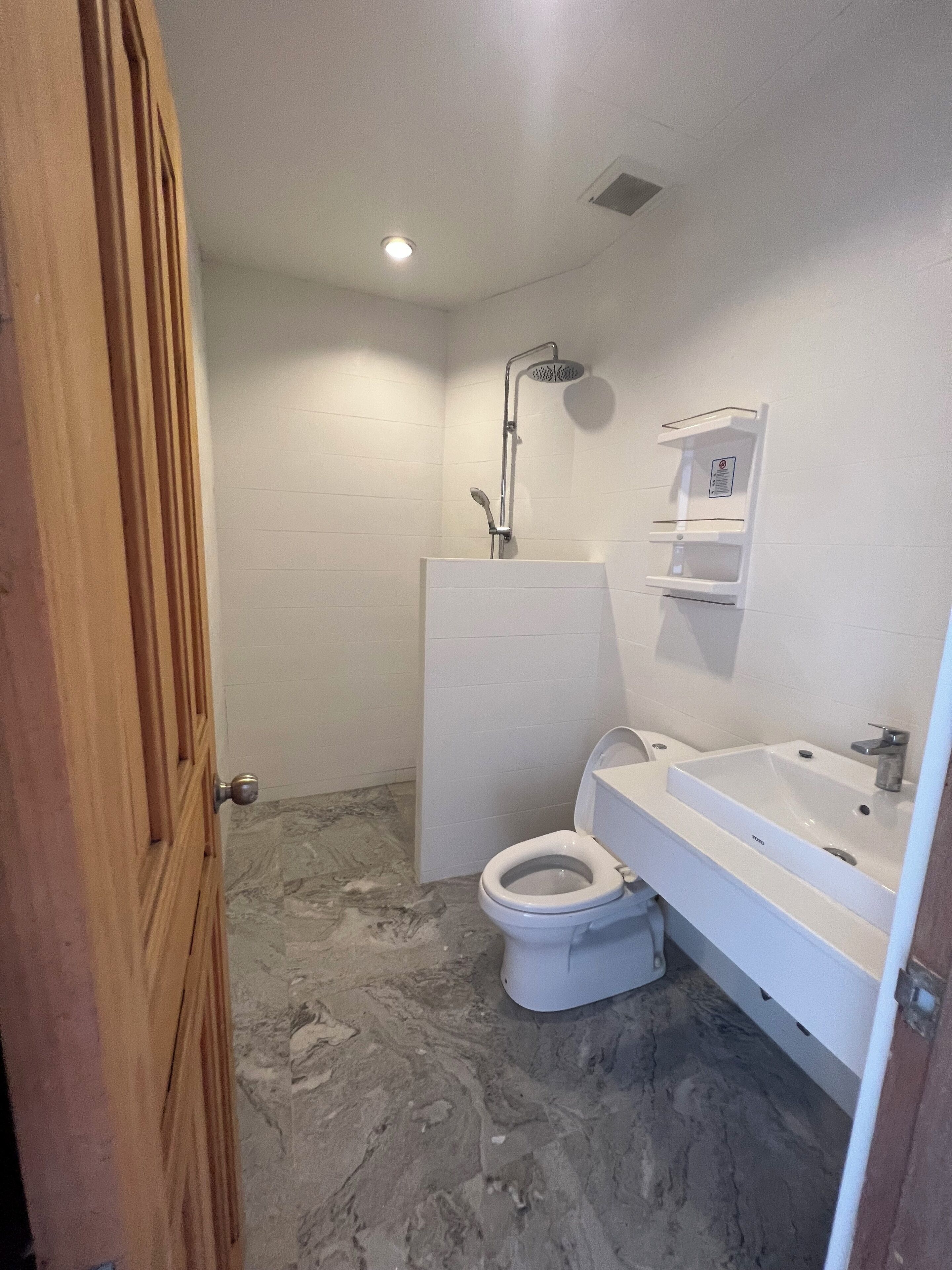 A bathroom with a shower, toilet, and sink.