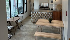 A modern interior with a dining area, a kitchen, and a balcony. - Calm and Green Place (Chiang Mai)