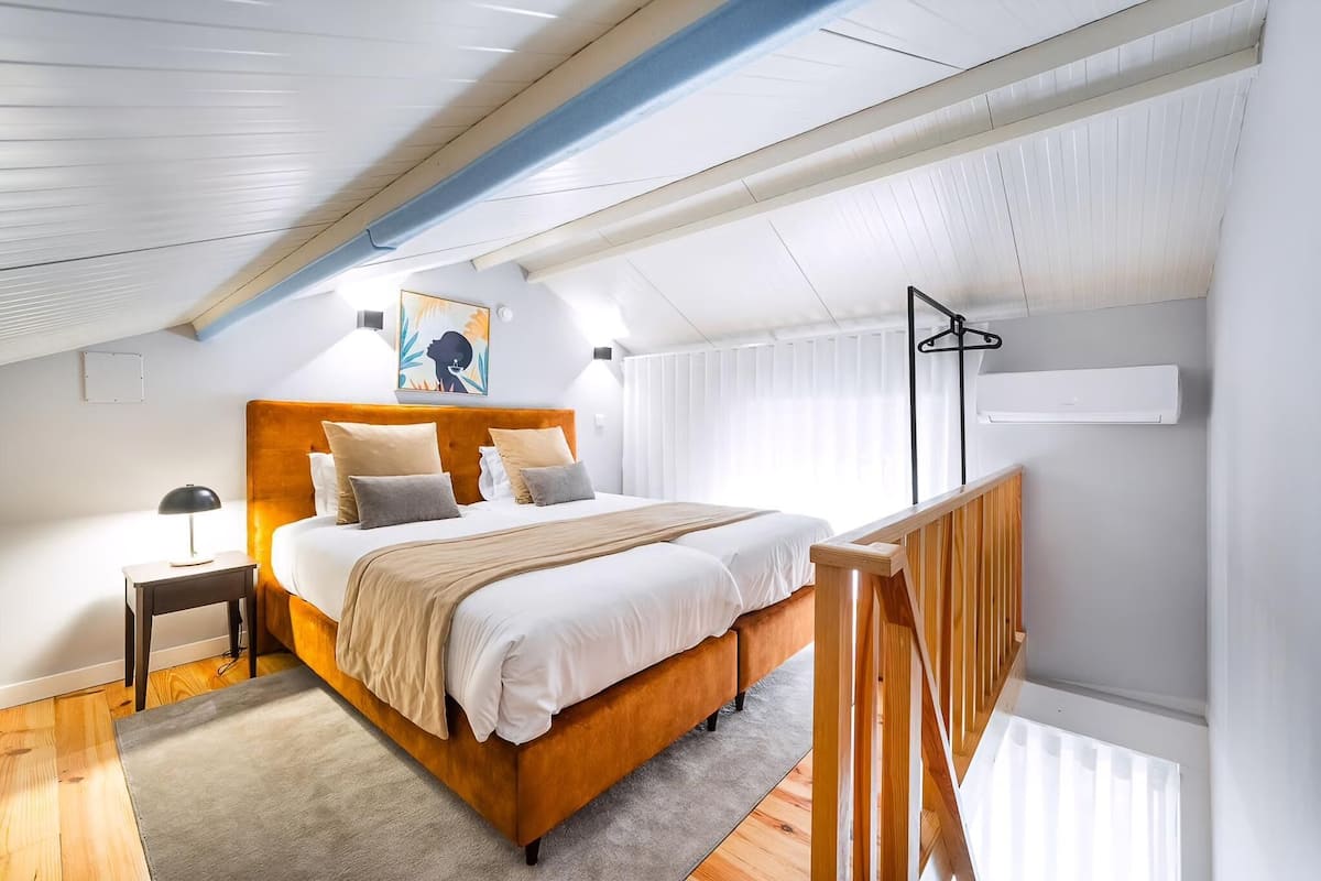 A bedroom with a wooden bed, a nightstand, a lamp, and a painting on the wall.