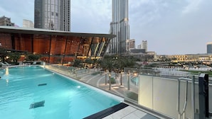 A modern hotel with a rooftop infinity pool, offering views of the city skyline and nearby high-rise buildings. - Gogoto1 2BR Burj Khalifa, Fountain View Dubai Mall (Downtown Dubai)