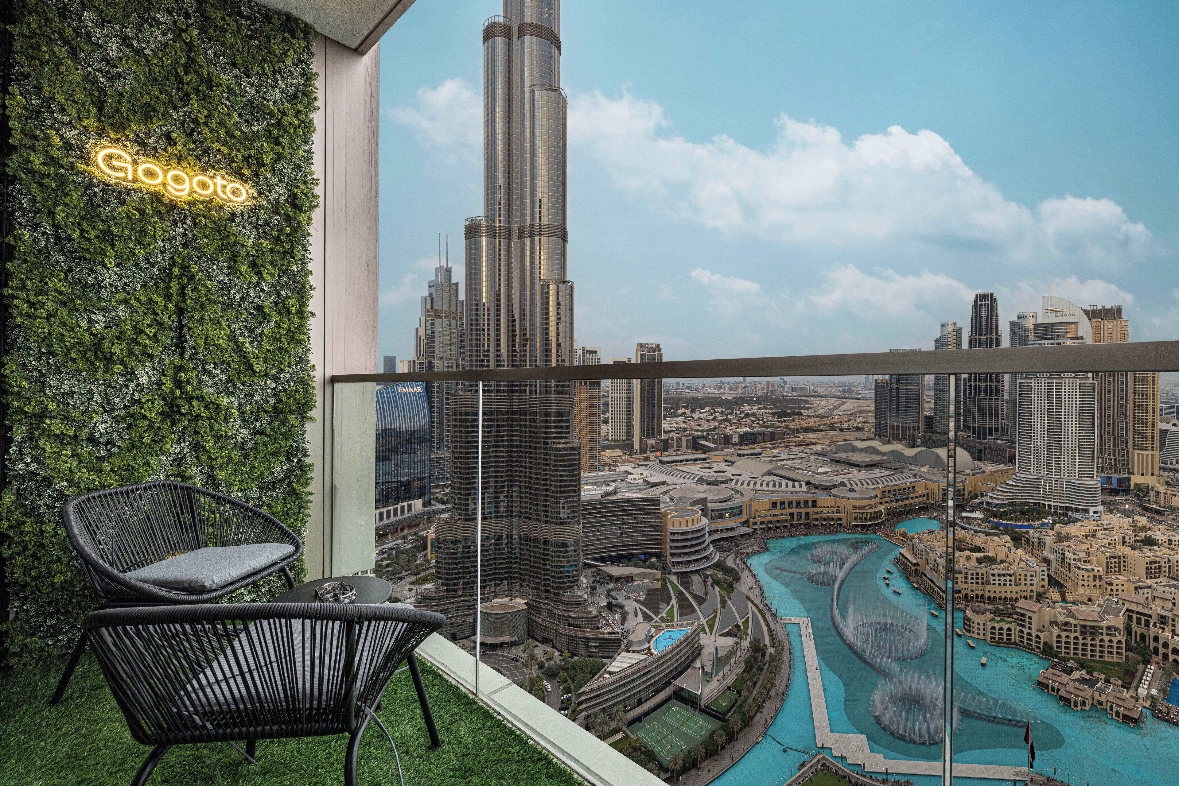 A balcony with a view of the Burj Khalifa and a pool area.