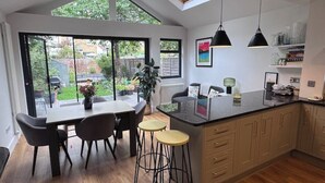 Una cocina moderna con una isla grande, taburetes de bar y una zona de comedor con mesa y sillas.
