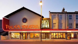Un edificio con un letrero que dice "Polka Theatre" y una tienda en la parte inferior.