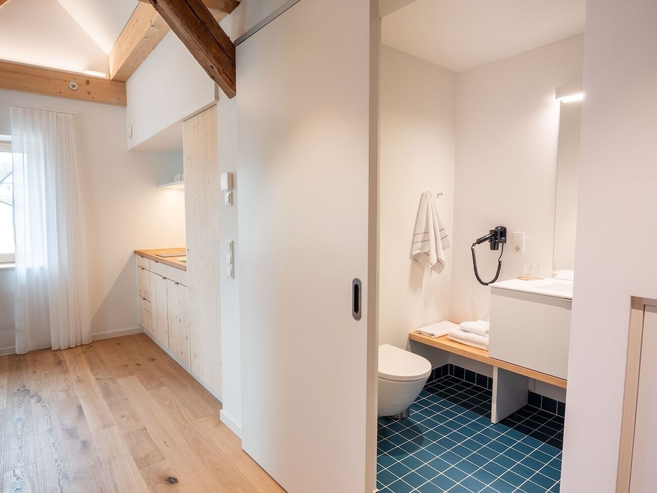 A modern bathroom with a toilet, sink, and towel rack.