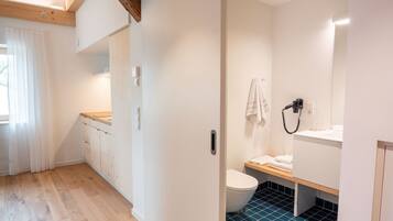 A modern bathroom with a toilet, sink, and towel rack.