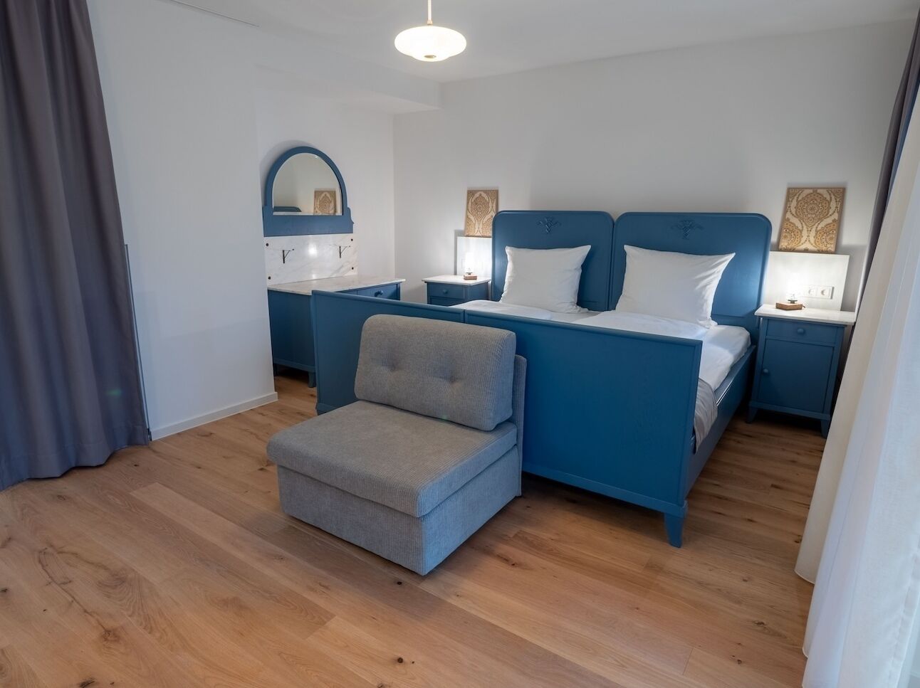 Una camera da letto con un letto, comodini, una sedia e uno specchio.