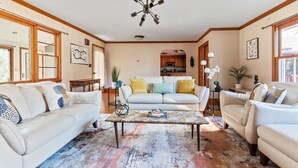 A living room with a white sofa, a coffee table, and a ceiling fan. - HV Spacious Retreat Sleeps 13 w Hot Tub (Poughkeepsie)