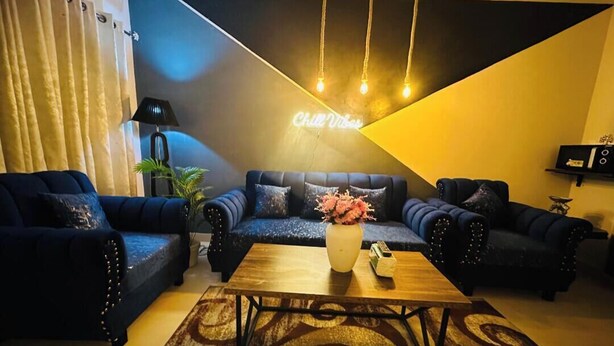 A modern living room with dark blue sofas, a wooden coffee table, and a decorative rug. - Skyline apartments, escape to the skys. Clean and peaceful (Rawalpindi)