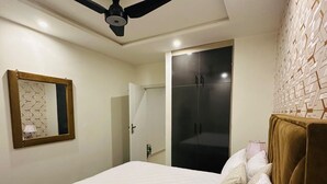 A bedroom with a bed, a ceiling fan, a wardrobe, and a mirror. - Skyline apartments, escape to the skys. Clean and peaceful (Rawalpindi)