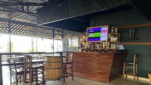 Eine Bar mit Holzkubaturen, einem Fernsehbildschirm und dem Heineken-Logo an der Wand.