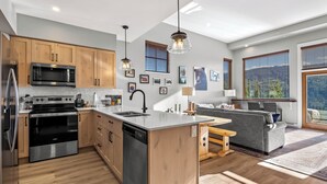 A modern kitchen with wooden cabinets, stainless steel appliances, and a central island.