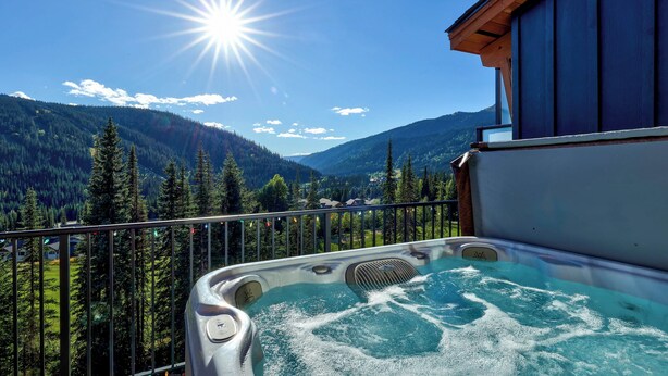 A hot tub on a balcony with a mountain view.