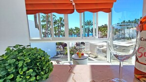 A bottle of Campo Viejo Rioja wine, a glass of wine, and a small table with a potted plant and fruit. - Vacation apartment EL PARAISO in Costa Calma, close to the beach, pool, terrace (Costa Calma)