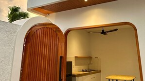 Una cocina moderna con puerta de madera, ventilador de techo y suelo de baldosas.