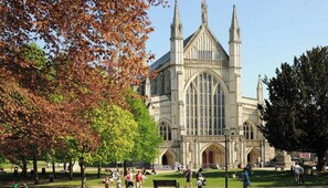 A historic building with a large arched entrance and two prominent towers. - Garden room, central Winchester – self-contained, kitchenette & parking (Winchester)