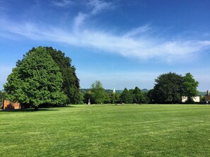 A grassy field with trees and a church steeple in the distance. - Garden room, central Winchester – self-contained, kitchenette & parking (Winchester)