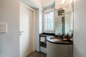 A modern bathroom with two sinks, a large mirror, and a window providing natural light. - The Residence of Garibaldi (Milan)
