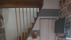 A staircase with wooden steps and a stone wall.