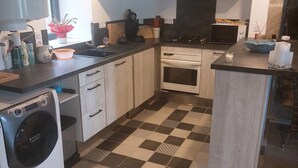 A modern kitchen with a washing machine, a microwave, and a stove.
