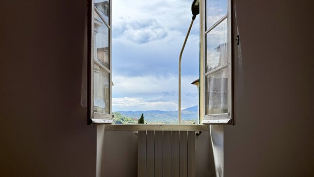 A room with a bed, a radiator, and a window with an open shutter. - La Casa de Rina (Imperia)