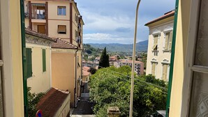 A narrow street with buildings on either side, a no parking sign, and a view of distant hills. - La Casa de Rina (Imperia)
