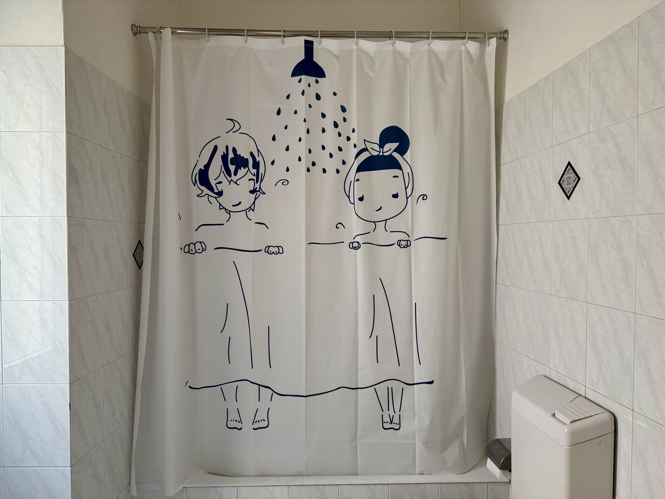 A bathroom with a shower curtain featuring a cartoon character design.