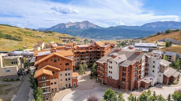 Un hôtel à plusieurs étages doté d’une cour intérieure, entouré de montagnes.