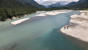 Een rivier met een zandige oever en een persoon aan de rechterkant.
